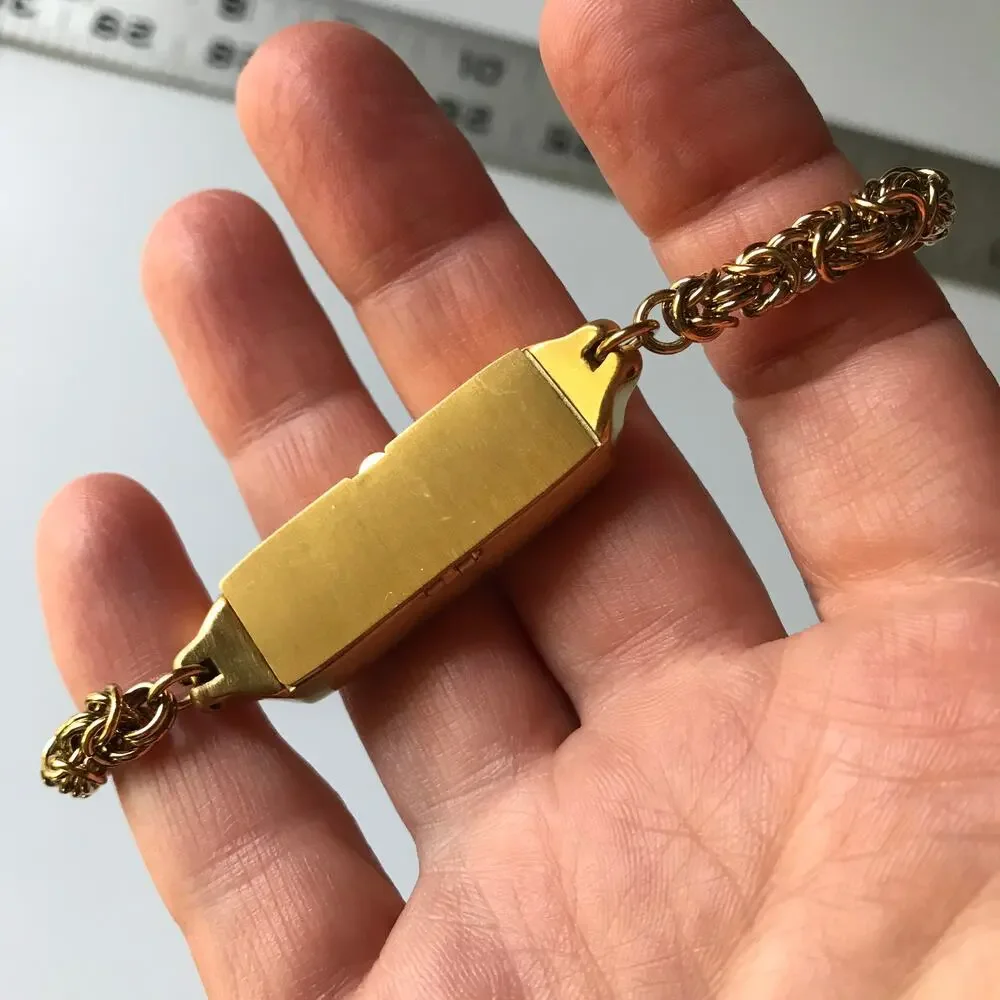 Brushed gold tone bracelet w/ a compartment for a fitbit device